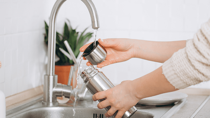 Using tap to wash a water bottle 